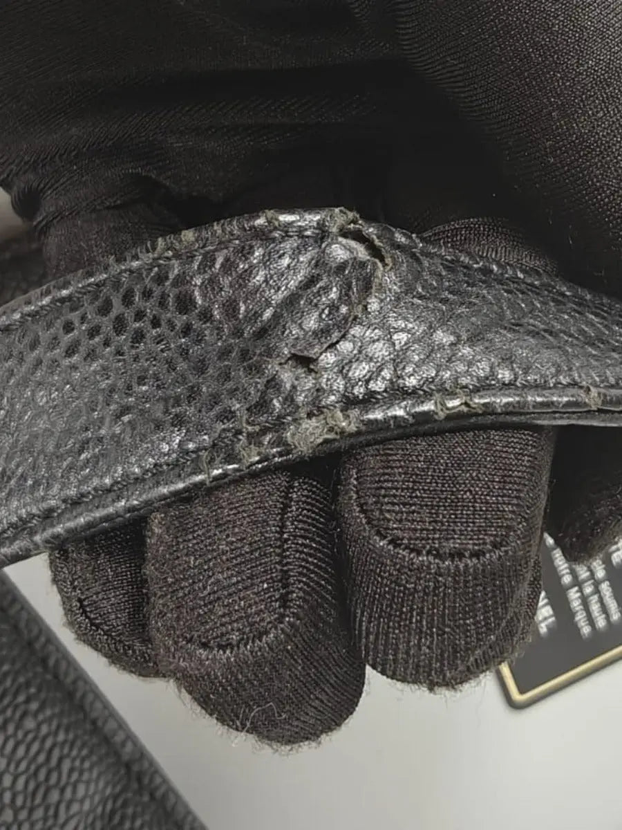 Détail de l'usure d'une anse sur un sac Chanel Shopper en cuir caviar